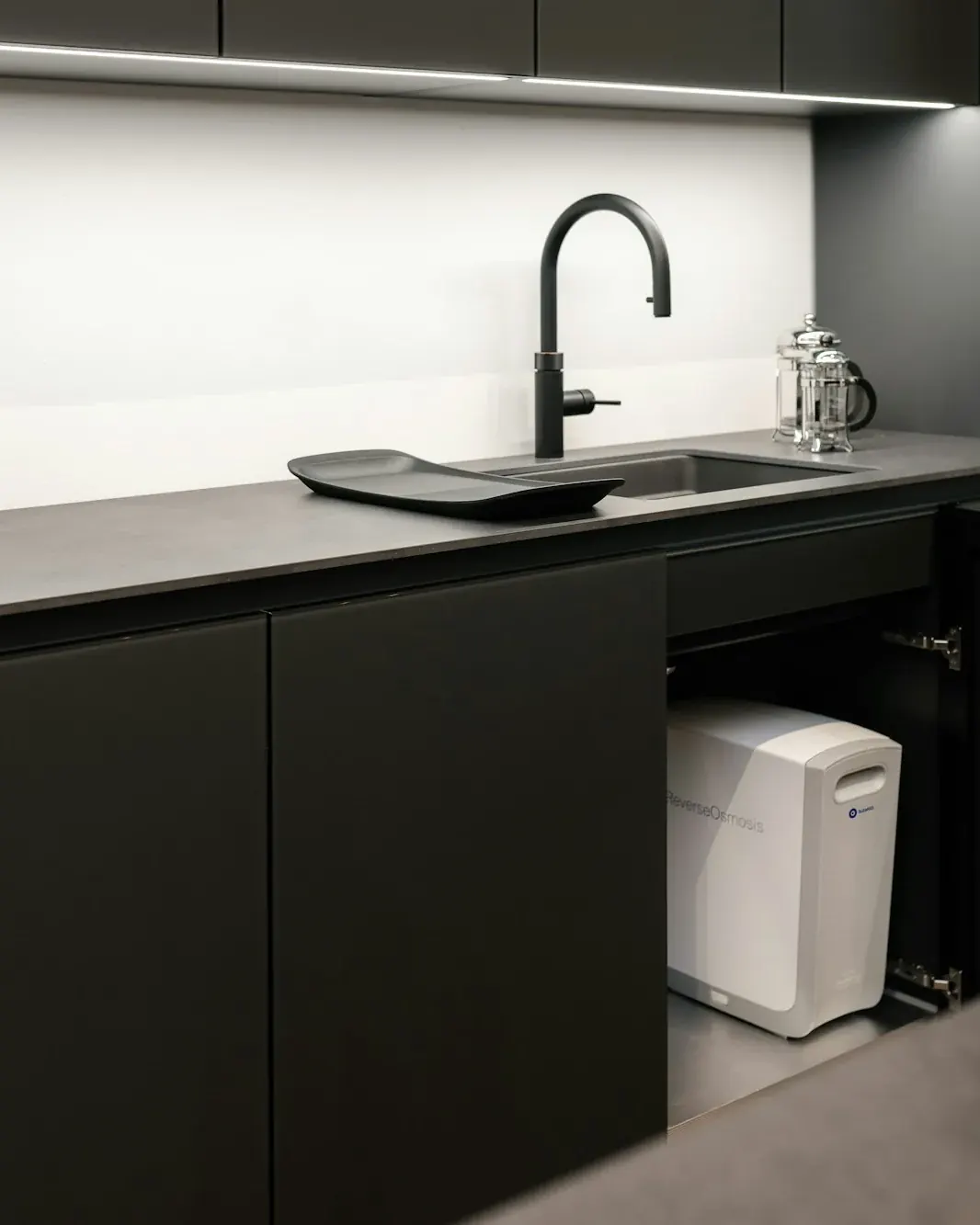 Clean modern kitchen with a compact filtration unit under the counter