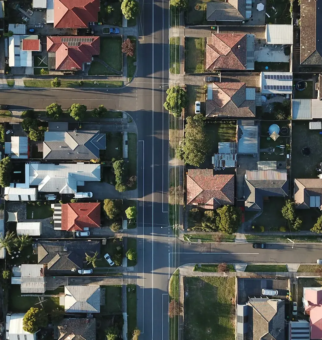 Aerial view of a suburban grid of homes and tree-lined streets
