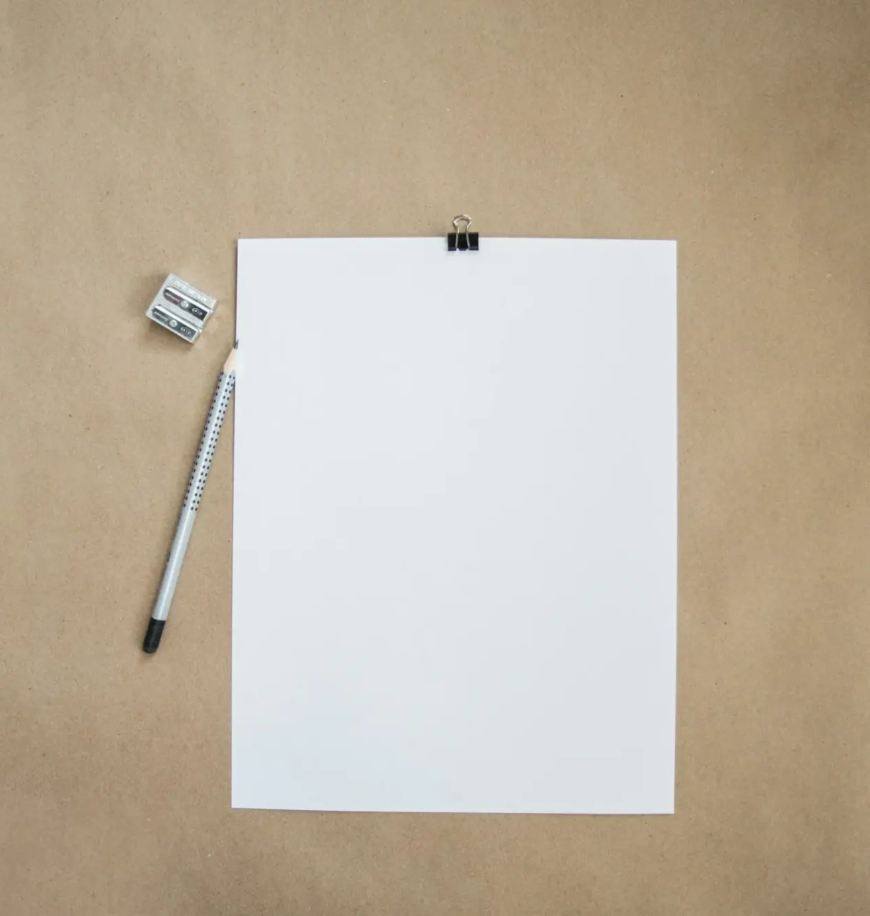 Sheet of white paper clipped beside a pencil
