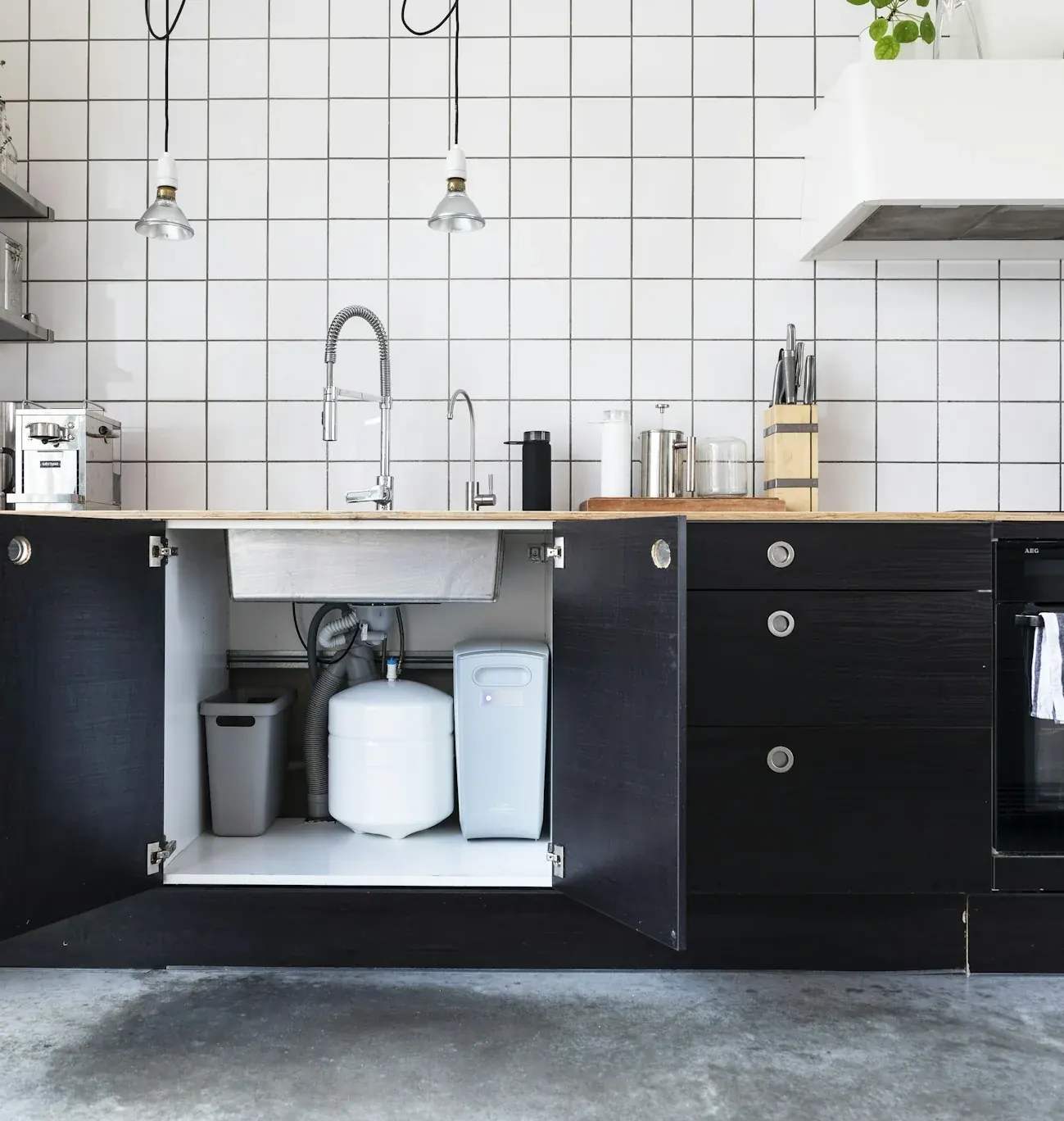 Modern kitchen with an under-sink filtration unit visible in an open cabinet